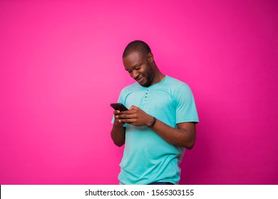 Handsome black pressing his phone with a smile on his face