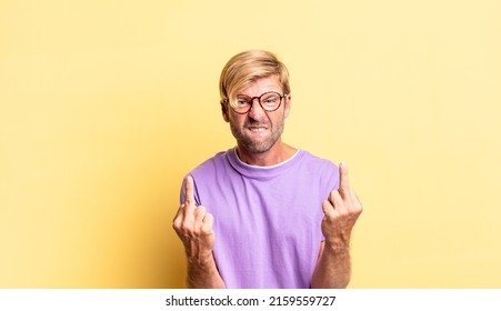 Handsome Blond Adult Man Feeling Provocative, Aggressive And Obscene, Flipping The Middle Finger, With A Rebellious Attitude