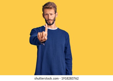 Handsome Blond Man With Beard Wearing Casual Sweater Pointing With Finger Up And Angry Expression, Showing No Gesture 