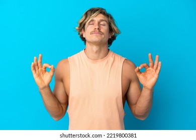 Handsome Blonde Man Isolated On Blue Background In Zen Pose