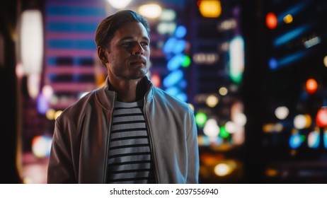 Handsome Blonde Man Standing on a Street of a Night City. Thoughtful Attractive Young Man Traveling, Looking Around Urban Center Contemplating Business Ideas, Future Career. Air of New Possibilities - Shutterstock ID 2037556940