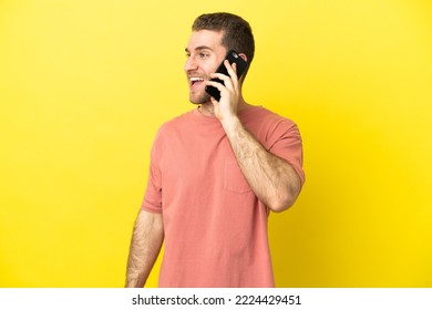 Handsome blonde man using mobile phone over isolated background laughing in lateral position - Powered by Shutterstock