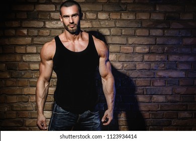 Handsome bodybuilder wearing black tank top with empty space for your text or logo