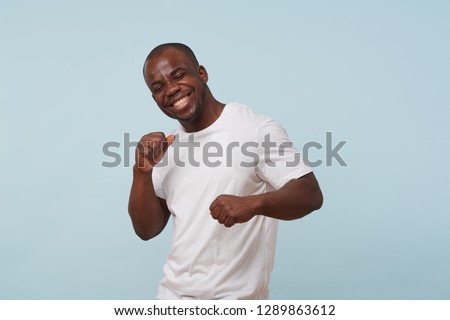 Similar – Cheerful man celebrating his success with a broad smile and raised fist in front of a neutral background