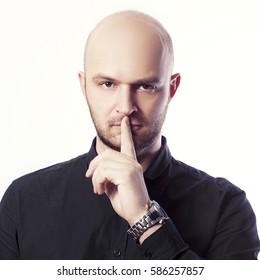 Handsome Bold Man With Finger On Lips Asking For Silence Over White Background. Studio Portrait. Toned