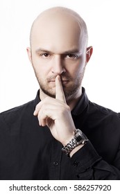 Handsome Bold Man With Finger On Lips Asking For Silence Over White Background. Studio Portrait