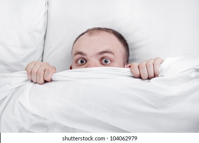 handsome boy in bed at home hiding under the blanket - Shutterstock ID 104062979