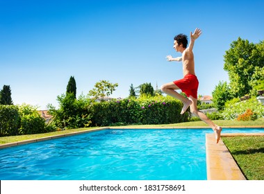 Handsome Boy Jump In Mid Air Into The Swimming Pool Water View From Side With Hands Up