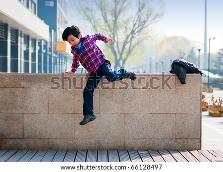 Handsome boy model jumping over wall