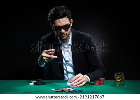 Handsome Brunet Pocker Player At Pocker Table With Chips and Cards While Thoughfully Sitting With Heap of Cards. Horizontal Image