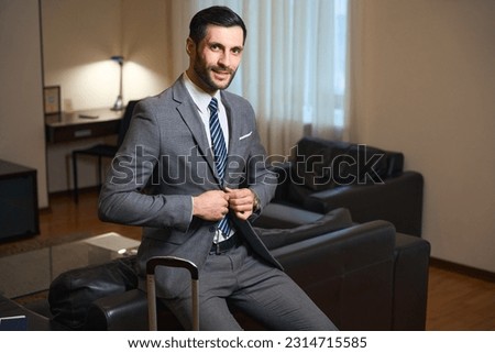 Handsome brunette sat down on the back of leather sofa Stock fotó © 