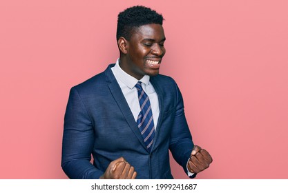 Handsome business black man wearing business suit and tie very happy and excited doing winner gesture with arms raised, smiling and screaming for success. celebration concept. 