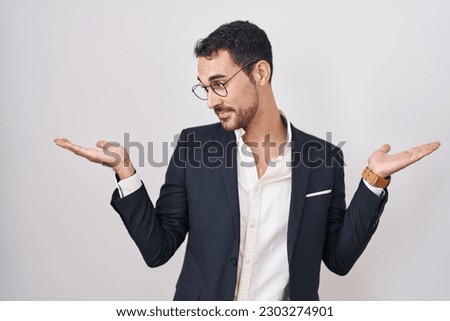 Handsome business hispanic man standing over white background smiling showing both hands open palms, presenting and advertising comparison and balance 