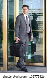 Handsome Business Man Leaving Building Through Revolving Doors