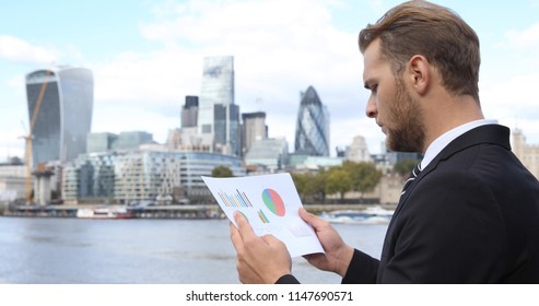 Handsome Business Man Looking On Pie Chart And Analyzing Financial Data London Skyline City Center