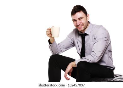 Handsome Business Man Sat Isolated On A White Background Holding Up A Mug Of Coffee