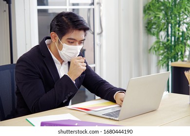 A Handsome Business Man, Sick With A Cough, Wears A Mask To Protect Himself From The Current Epidemic Situation At Work