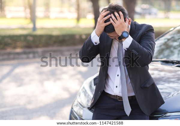 Handsome
businessman with breakdown car on the
road