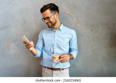 Handsome Businessman Checking Emails On The Phone In Modern Office In Coffee Break