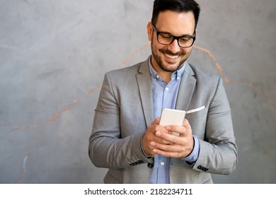 Handsome Businessman Checking Emails On The Phone In Modern Office In Coffee Break