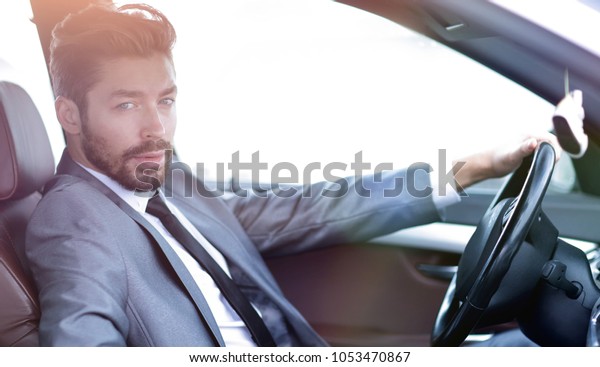 Handsome\
businessman in the drivers seat in his\
car