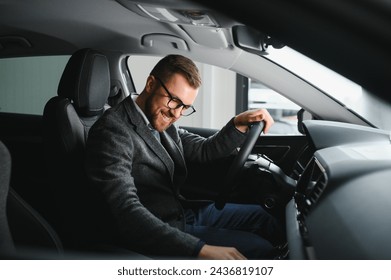 Handsome businessman driving car to airport, going on business side view, copy space. Happy man in stylish suit going to business meeting in the morning, driving his luxury car, shot from cabin - Powered by Shutterstock