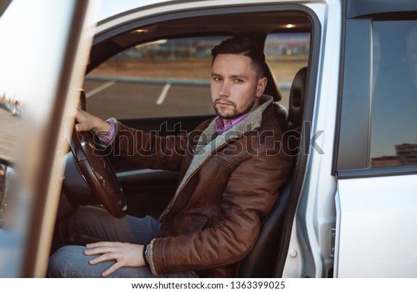 Handsome\
businessman driving car before buying. Successful man sitting\
behind the wheel of a prestigious\
car.