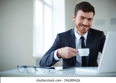 Handsome Businessman Having Tea Or Coffee In Office