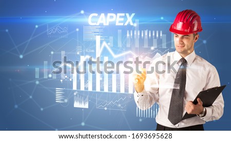 Handsome businessman with helmet drawing CAPEX inscription, architecture business plan concept