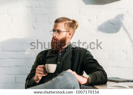 handsome businessman holding cup of coffee and looking away Stock photo © 