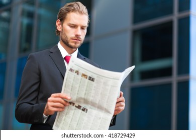     handsome businessman holding a newspaper 