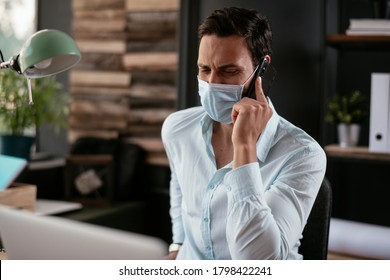 Handsome businessman with medical mask. Young man talking to the phone in office.	 - Powered by Shutterstock