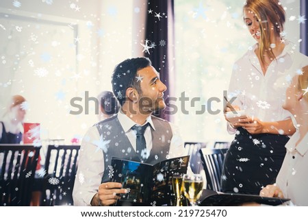 Handsome businessman ordering food from waitress against snow