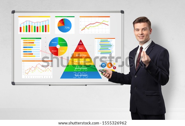 Handsome businessman presenting health reports on\
white board with laser\
pointer