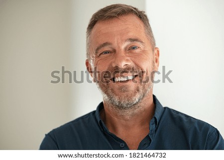 Handsome businessman smiling and looking at camera. Portrait of carefree mature man with copy space. Successful mid adult business man laughing.