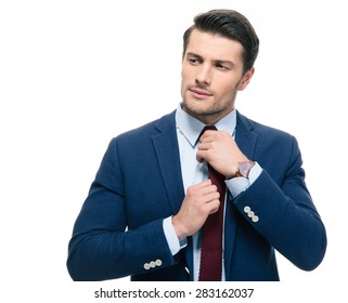 Handsome businessman straightening his tie isolated on a white background