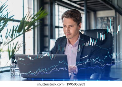 Handsome businessman in suit at workplace working with laptop to optimize trading strategy at corporate finance fund. Forex chart hologram over office background