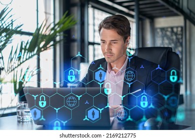 Handsome businessman in suit at workplace working with laptop to defend customer cyber security. Concept of clients information protection and brainstorm. Padlock hologram over office background. - Powered by Shutterstock