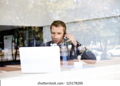 Handsome Businessman Talking On The Phone In Coffe Shop.