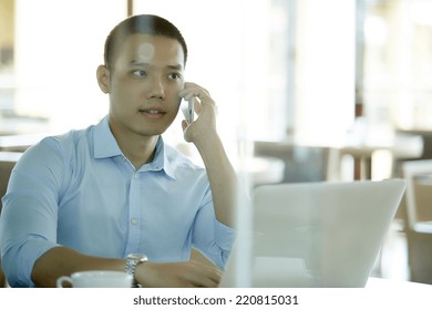 Handsome Businessman Talking On The Phone In Coffe Shop.