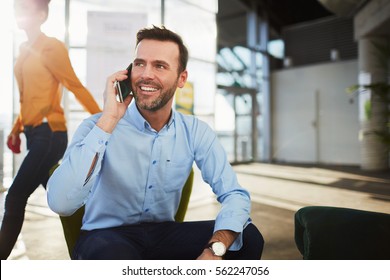 Handsome businessman talking on the phone during coffee break in a cafe - Powered by Shutterstock