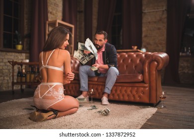 Handsome businessman trowing dollard in front of sexy lady in lingerie. Being in late office.