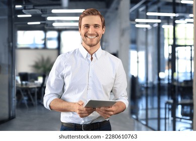 Handsome businessman using his tablet in the office - Shutterstock ID 2280610763