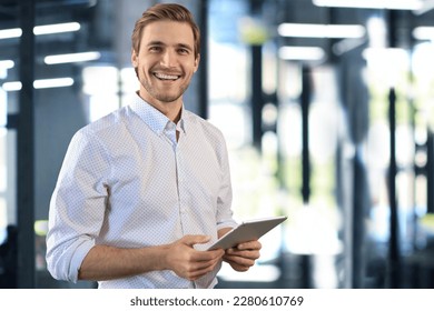 Handsome businessman using his tablet in the office - Shutterstock ID 2280610769