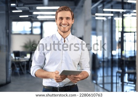 Handsome businessman using his tablet in the office