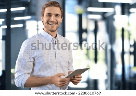 Handsome businessman using his tablet in the office