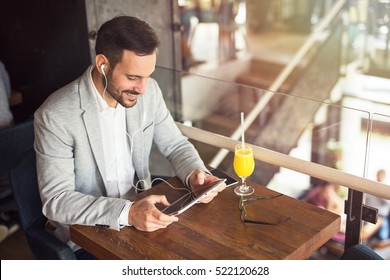 Handsome businessman using tablet at city cafe.
 - Powered by Shutterstock