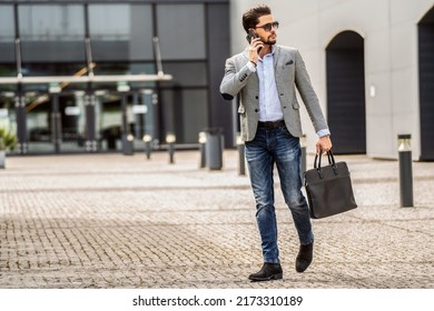 Handsome Businessman Walking On The Street, Talking Via Mobile Phone. Fashionable Style. Male Model. Outdoor Photo.