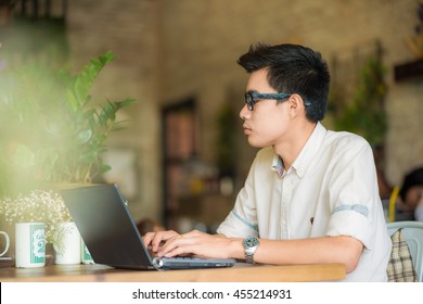 Handsome Businessman Working With Laptop In Vintage Loft Coffe Shop, Asian Hipster Man