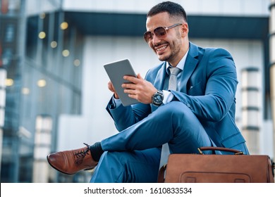 Handsome businessman working with tablet and touching display.